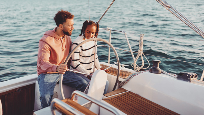 Proud father showing his daughter how to sail a yacht. Family Yacht Sailing. Luxury vacation at sea.