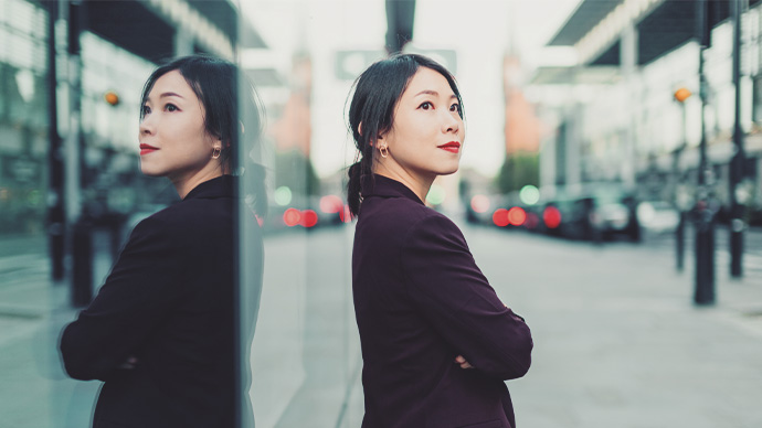 Young confident Asian woman with arm crossed, standing on the street. Looking successful and profession. Female leadership concept.