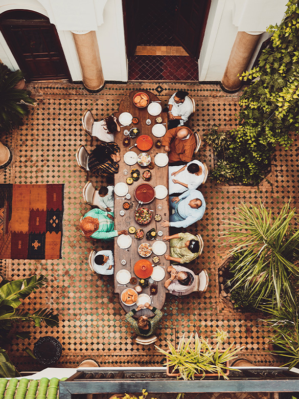 Wide shot overhead view of family gathered at dining room table for multigenerational family dinner celebration